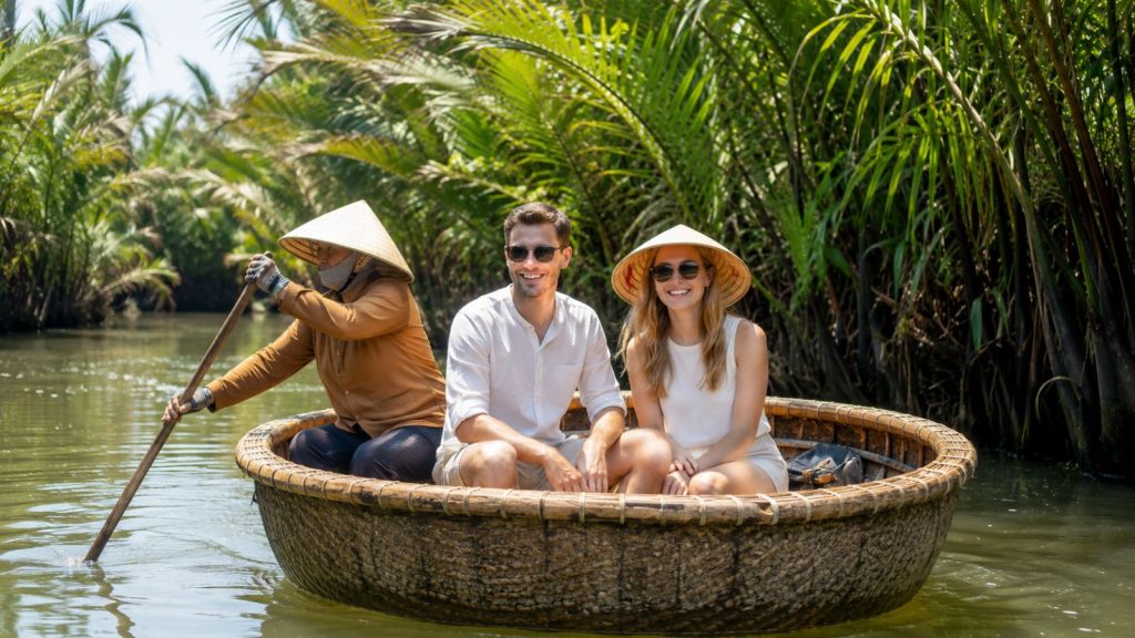 Tourists enjoy a basket boat ride through Cam Thanh Coconut Forest in Hoi An, guided by a local rower along a lush palm-lined canal.
