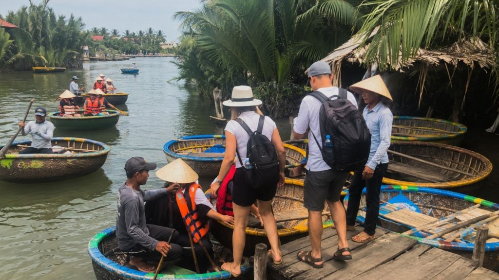 Best Cam Thanh Coconut Village Tour for a Unique Hoi An Experience 6 Tourists boarding basket boats at a Cam Thanh riverside dock.