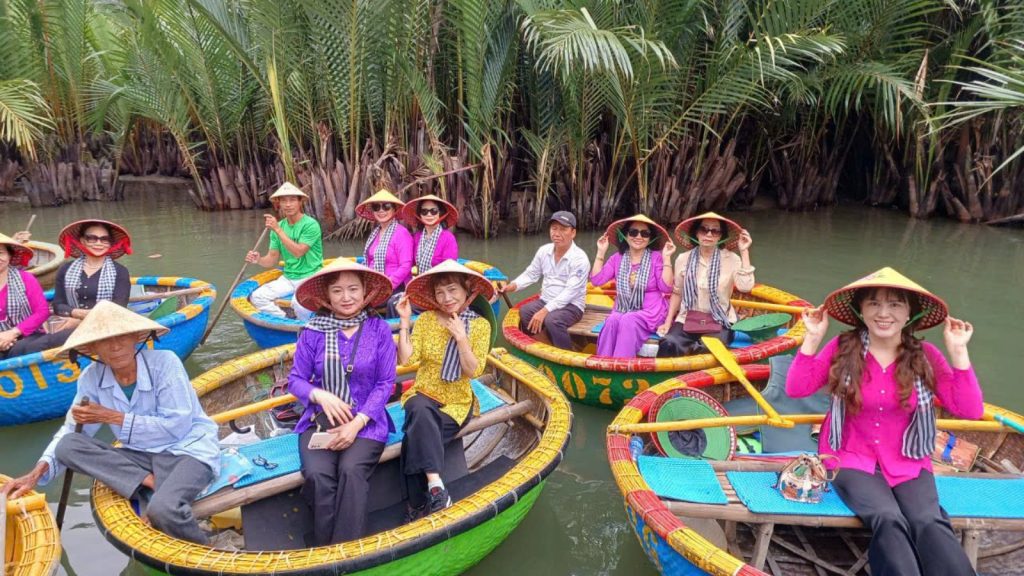 Groups of tourists ride colorful basket boats through Cam Thanh Coconut Forest, enjoying a lively eco-tour experience in Hoi An.