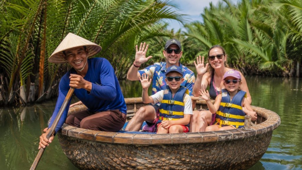 Best Cam Thanh Coconut Village Tour for a Unique Hoi An Experience 2 Family waving during a basket boat tour through the coconut palms in Hoi An.