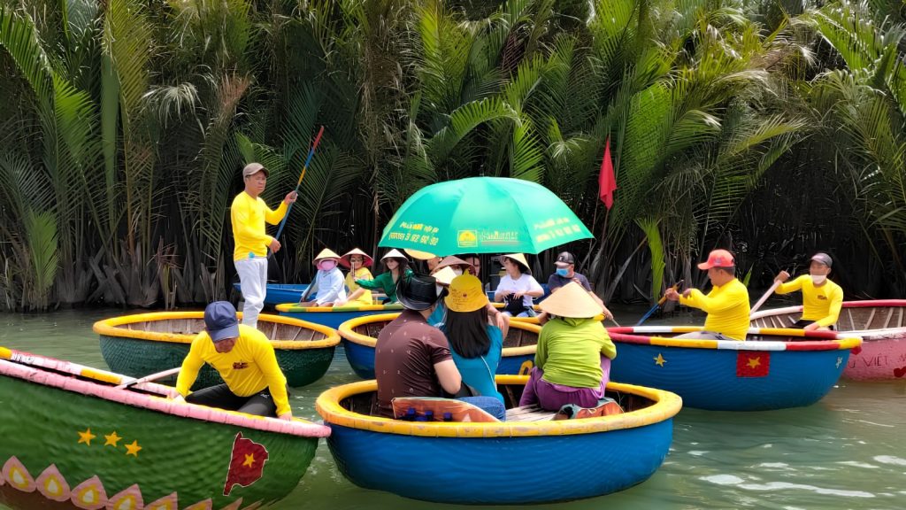 Many basket boats carrying Vietnamese and international tourists through the coconut palm forest in Hoi An