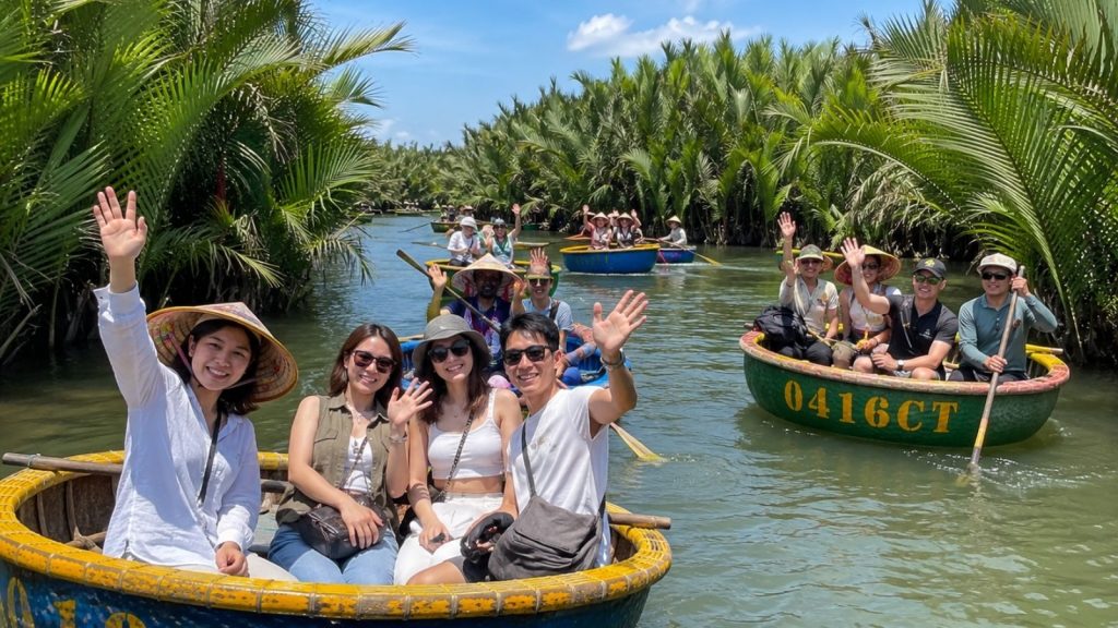 Group of friends waving from round basket boats on a calm canal at Coconut Forest.