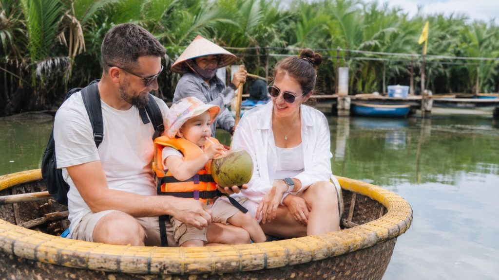 Toddler wearing a life jacket while drinking coconut on a basket boat.