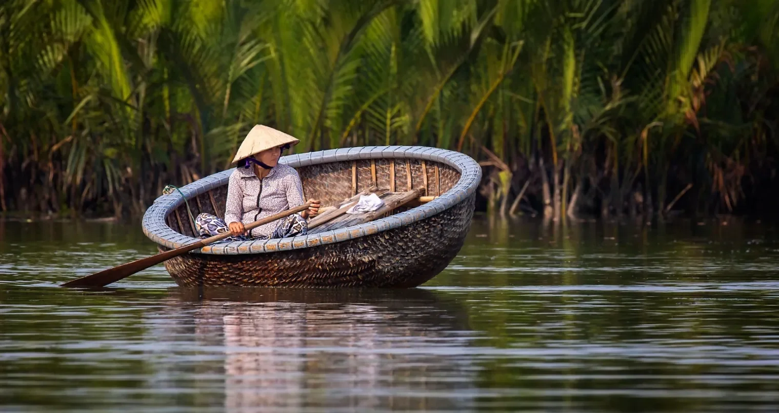 Basket Boat Spinning Performance Hoi An: What to Expect & Tipping Guide 2 Traditional handwoven bamboo basket boat coracle with local fisherman paddling through nipa palm canals in Hoi An