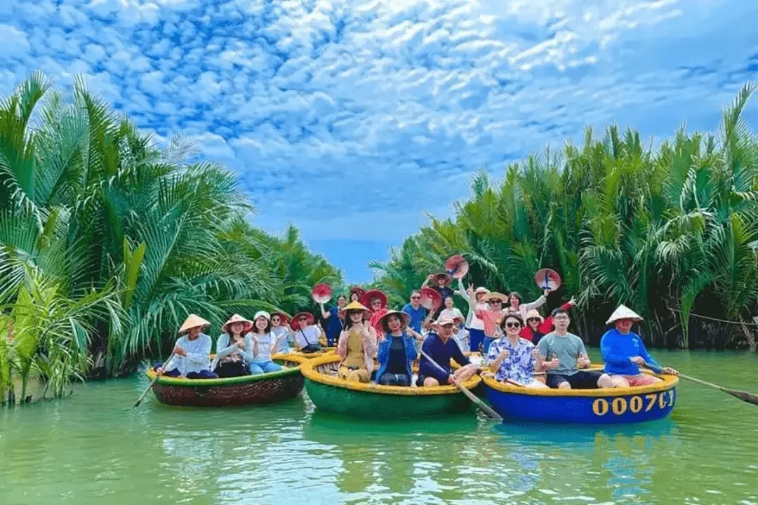 Group of travelers laughing and enjoying shared basket boat tour on the river at Cam Thanh Hoi An coconut forest
