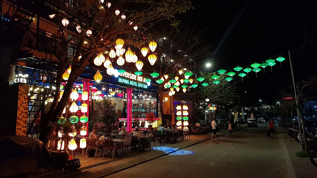 Glowing paper lanterns and wooden boats on Hoai River in Hoi An at night