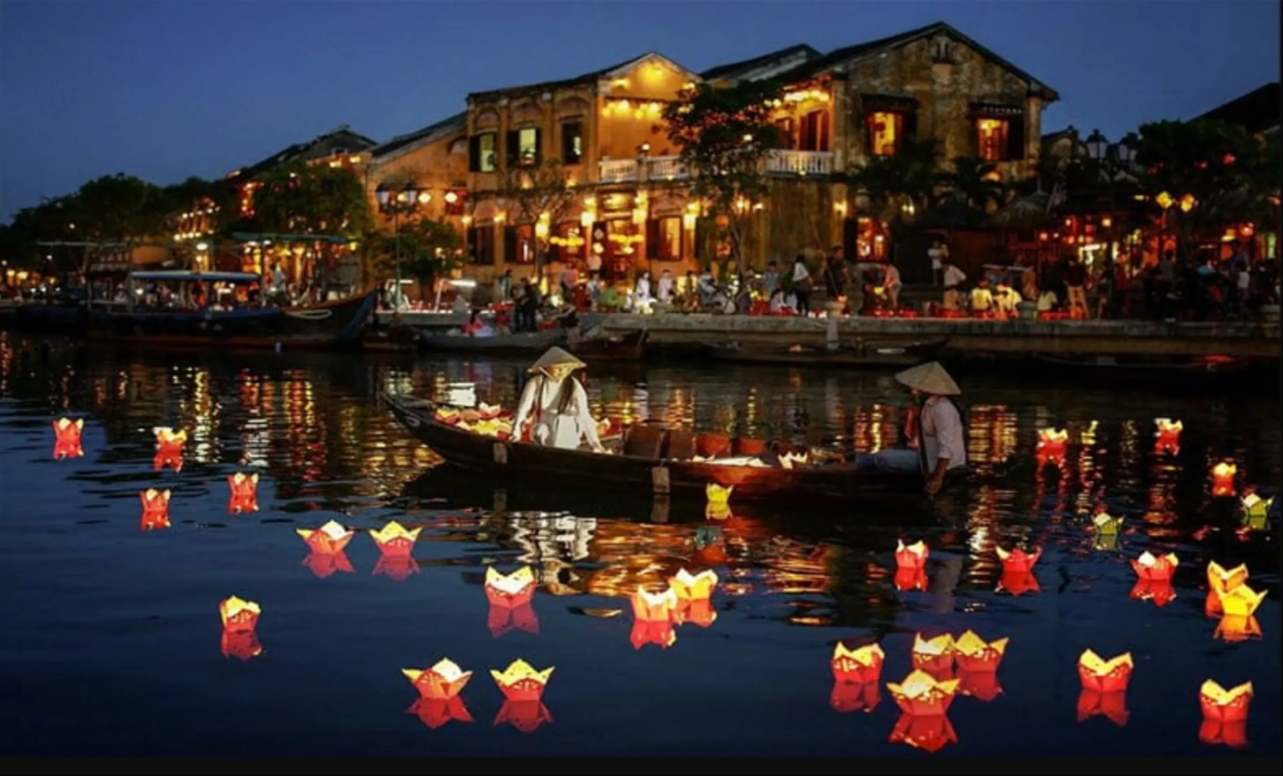 Vibrant Hoi An Ancient Town at night with thousands of colorful silk lanterns reflecting on the Thu Bon River