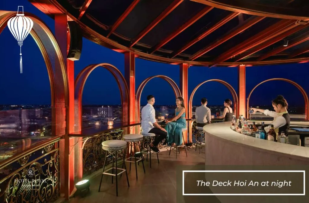 Rooftop cocktail bar overlooking the illuminated Hoi An Ancient Town skyline and Thu Bon River at night