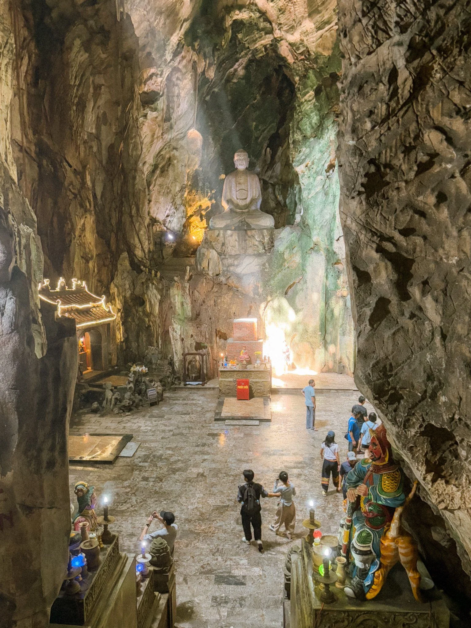 Dramatic sunlight beams streaming through the ceiling opening of Huyen Khong cave into the ancient Buddhist temple inside Marble Mountains