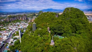 Panoramic view from Marble Mountains peak showing Da Nang city skyline and South China Sea coastline stretching to the horizon