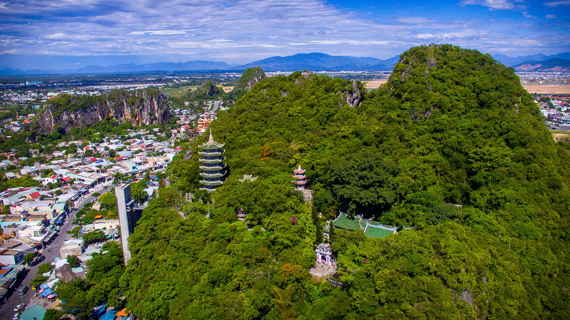 Panoramic view from Marble Mountains peak showing Da Nang city skyline and South China Sea coastline stretching to the horizon