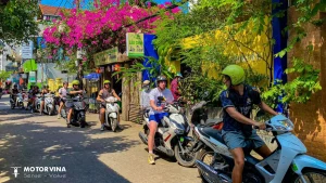 Travelers riding rented scooters along the scenic coastal highway from Da Nang to Hoi An with ocean views in Vietnam