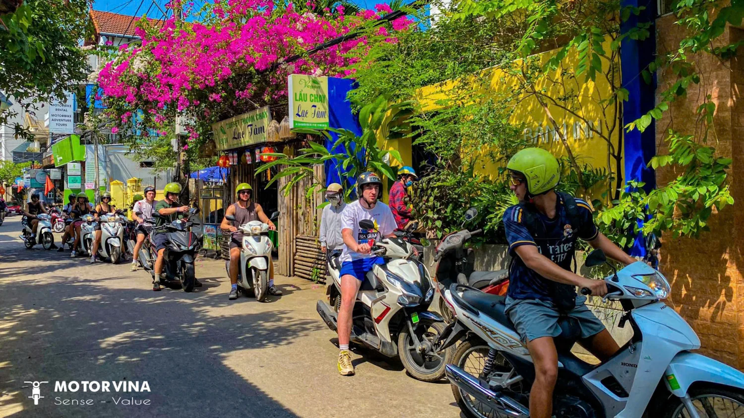 Travelers riding rented scooters along the scenic coastal highway from Da Nang to Hoi An with ocean views in Vietnam