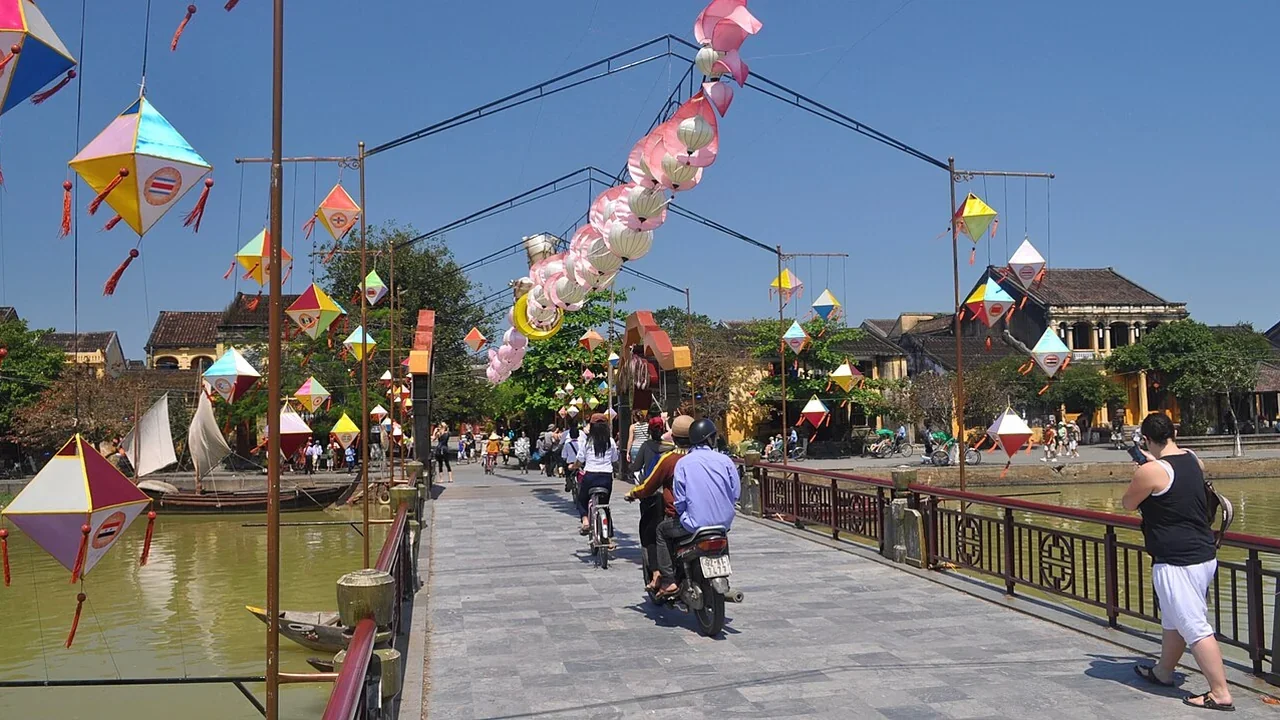 Pedestrians crossing bridge over Thu Bon River in Hoi An Ancient Town